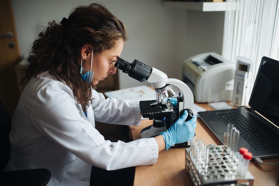 Laboratory technician using a microscope in a medical laboratory
