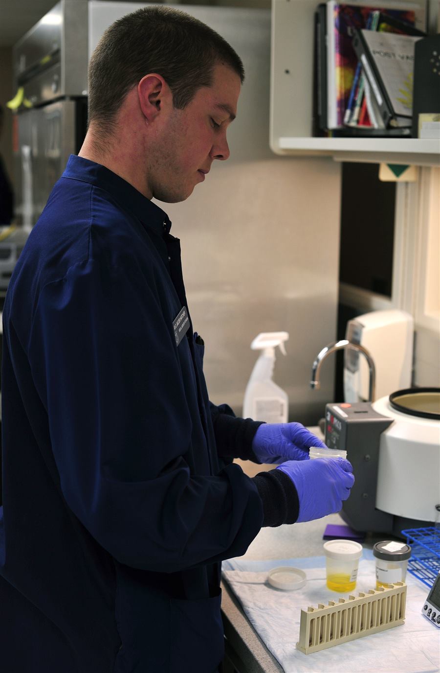 Medical laboratory technician in a lab coat performing a laboratory procedure